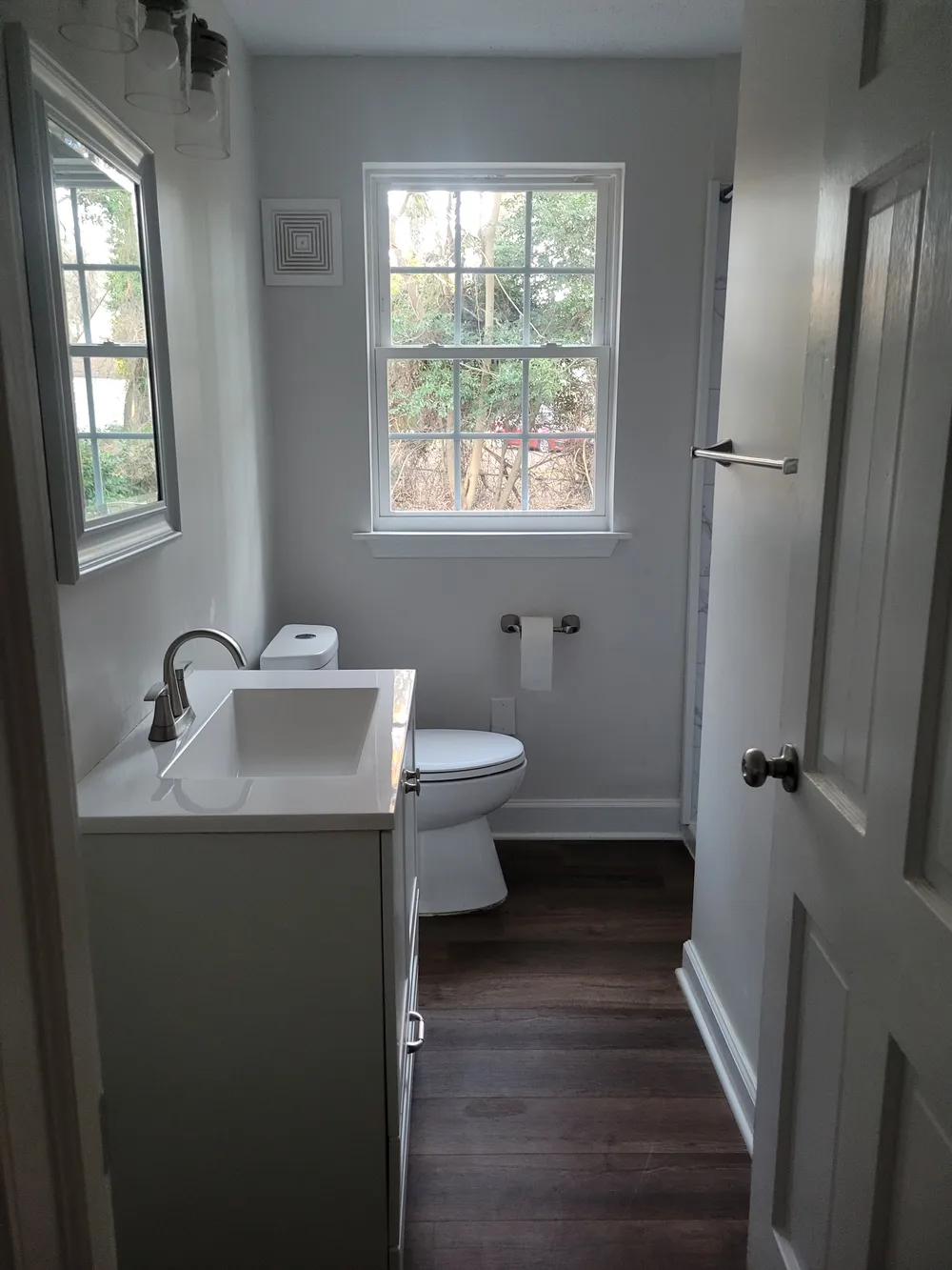 Bathroom vanity below a window with gray walls