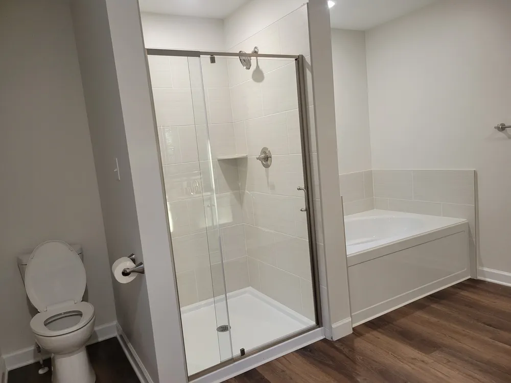 Bathroom with a glass shower beside a bathtub