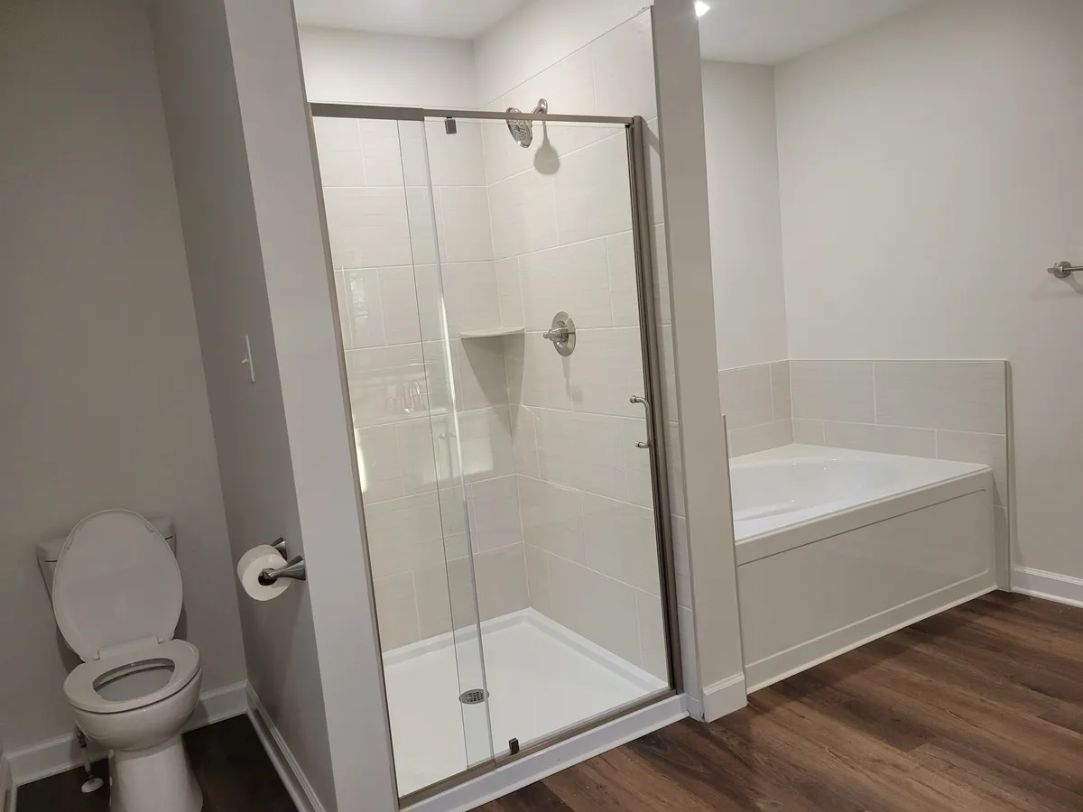 Bathroom with a glass shower beside a bathtub