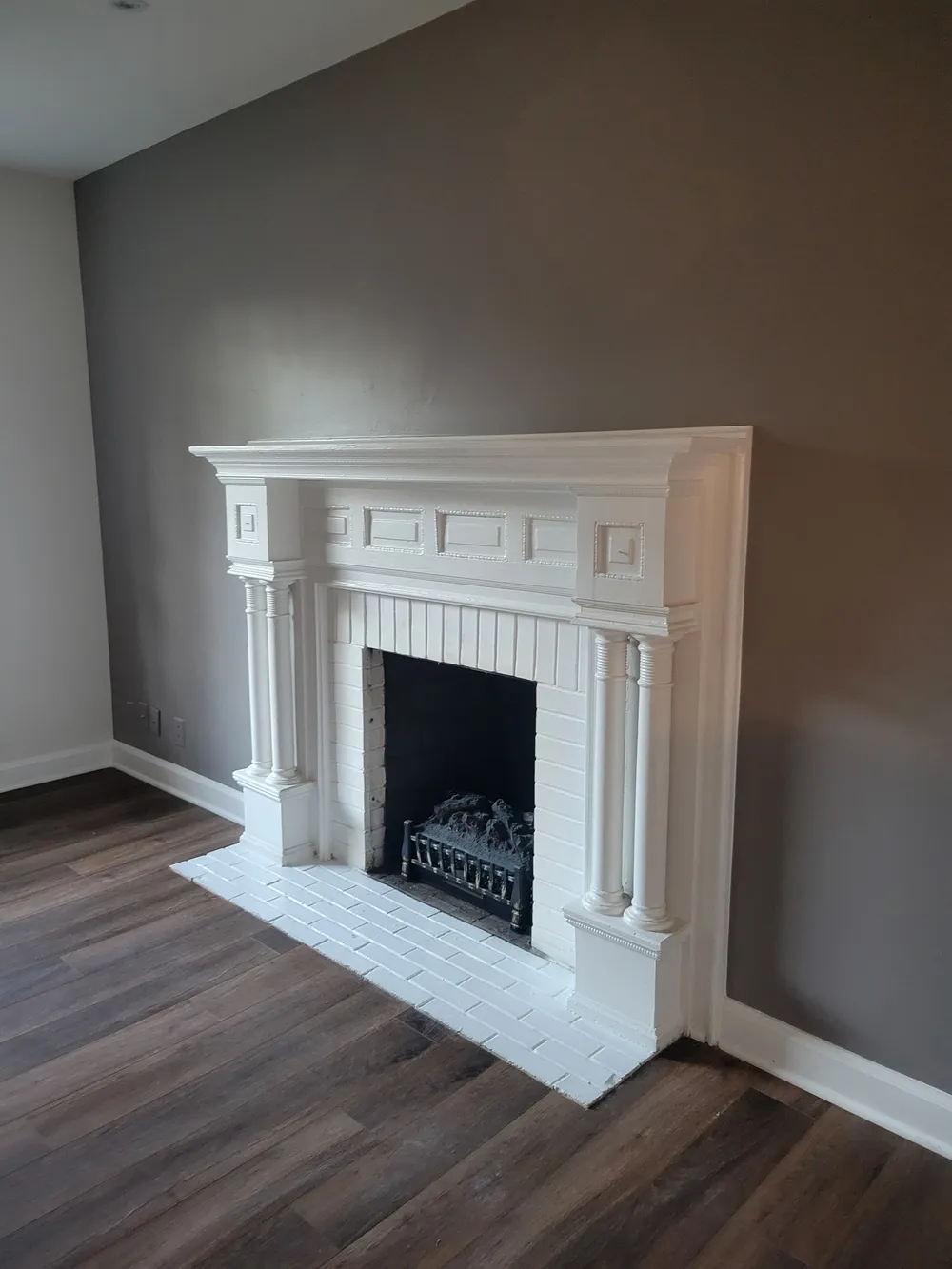 White mantel and dark wood flooring in a living room